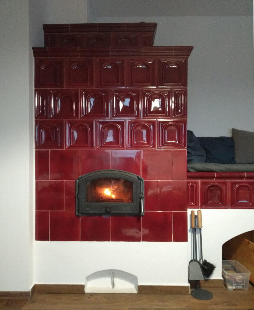 kachlová kamna v rohu s vyhřívaným ležením červená